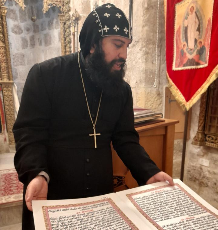 Ortodoksimunkki Boulus näyttää kirjoja, johon hän on taidokkaasti korutekstannut raamatunlauseita ja rukouksia.
