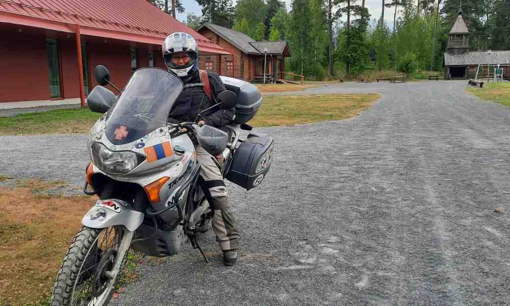 Kanttori Minna Jokinen poseeraa moottoripyöränsä kanssa Kaunisniemen leirikeskuksessa