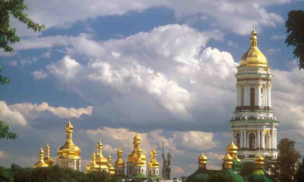Kiovan luolaluostarin kultaiset kirkkojen kupolit piirtyvät pilvistä kesätaivasta vasten