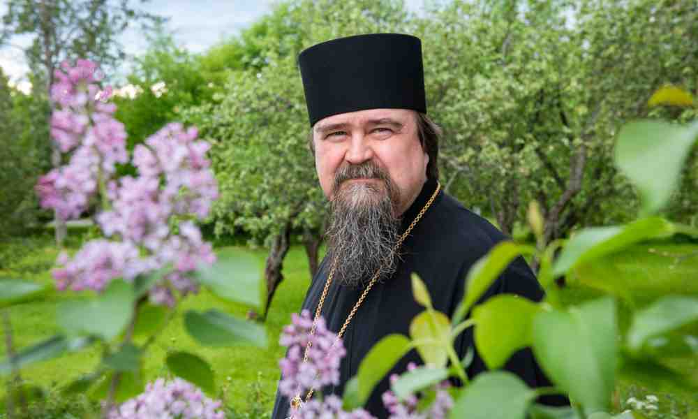 Haminan piispa Sergei kuvattuna kukkien keskellä Valamon luostarin puutarhassa